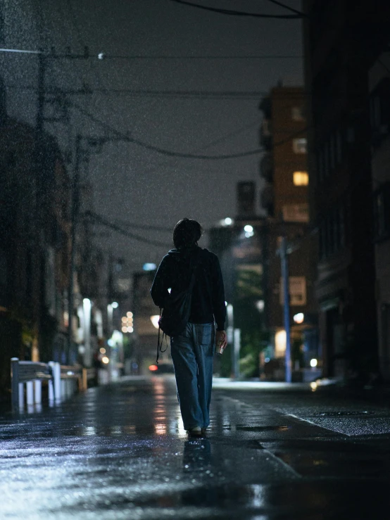 a man walking down the street in the dark