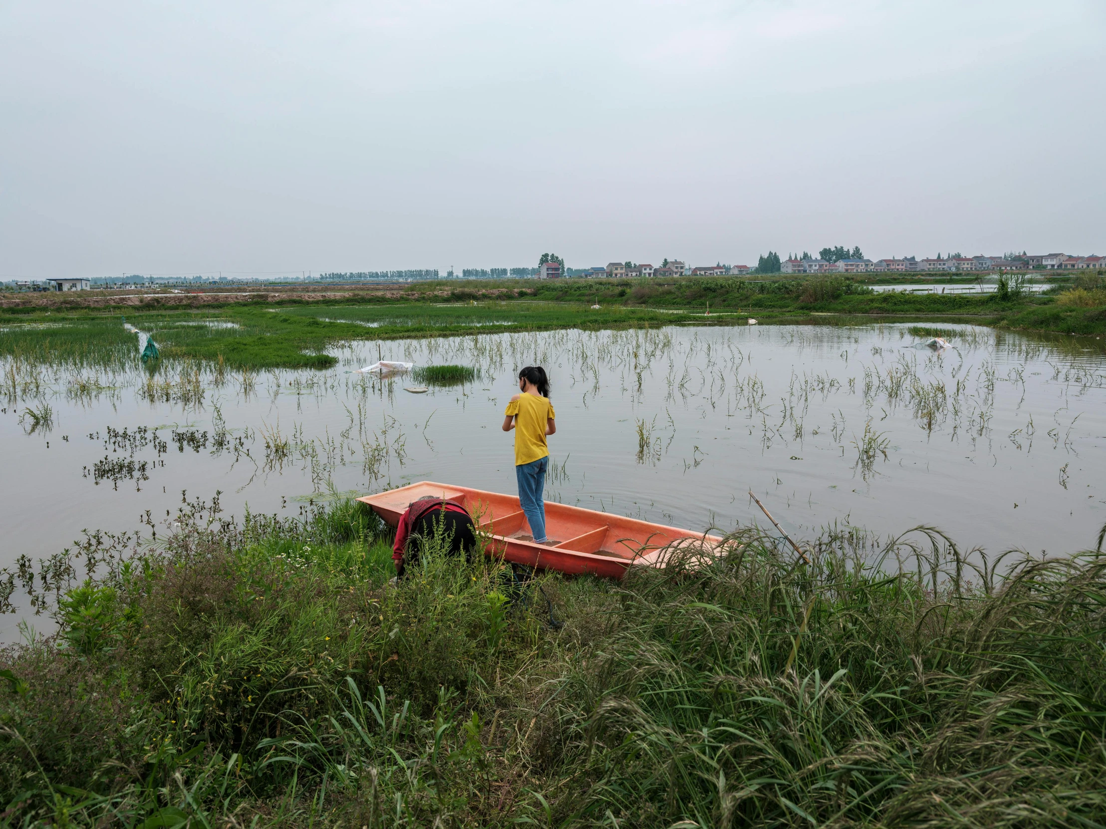 man standing on a small boat out in the water