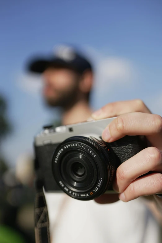 there is a person holding a camera near his face