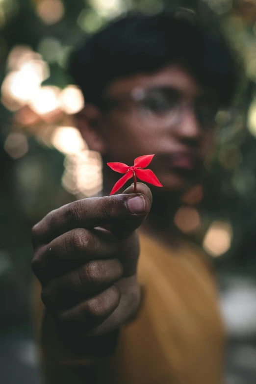 a  holding a red piece of paper in his hand