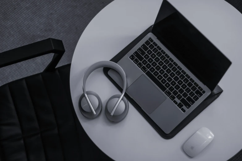 a laptop, headphones, and computer on a table