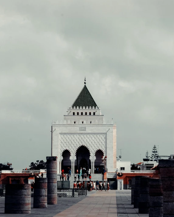 a clock tower towering over a plaza on a cloudy day