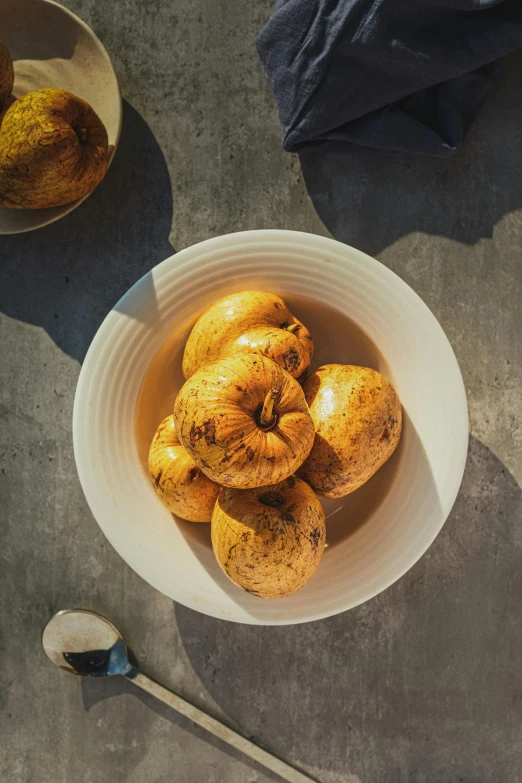 a bowl of cinnamon buns sitting on the ground