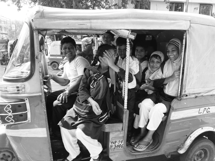 the group of people are sitting in the back of an auto