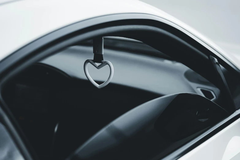 a heart hanging from the handle of a car