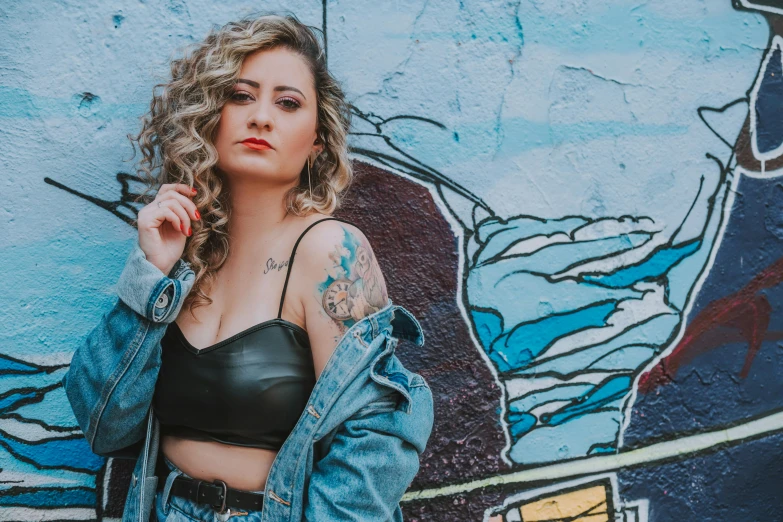 a woman with big  standing against a painted wall