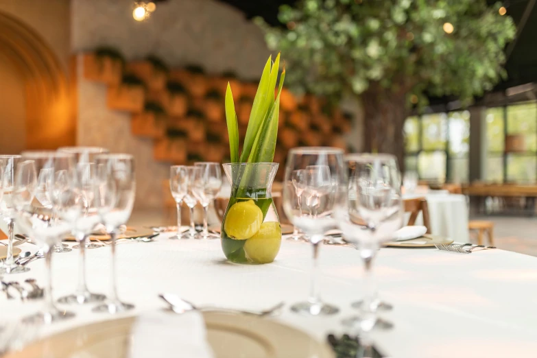 some white glassware and a table with a bottle and lemon