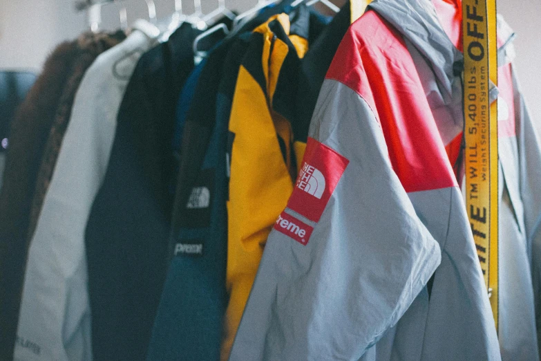 there are several jackets hanging up with yellow and red