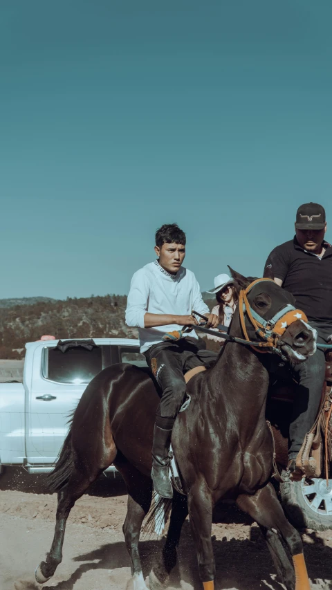 two men on horses in front of a truck