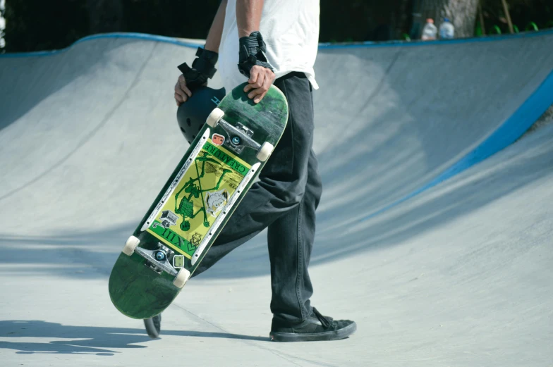 a boy holding his skateboard while in a skate park