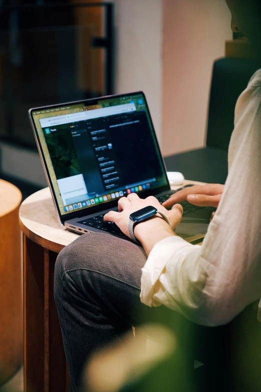 a person sitting on their lap while using a laptop