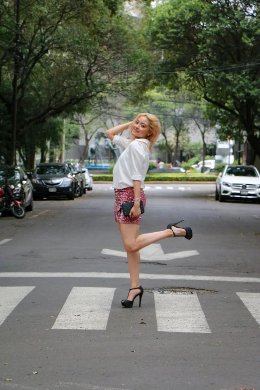 a woman is posing while crossing the street