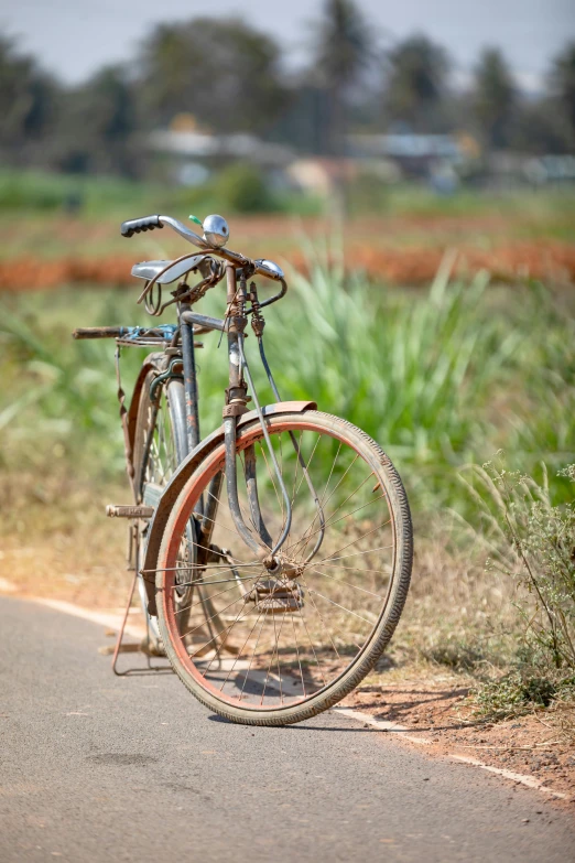 an old bicycle leaning on the side of a road