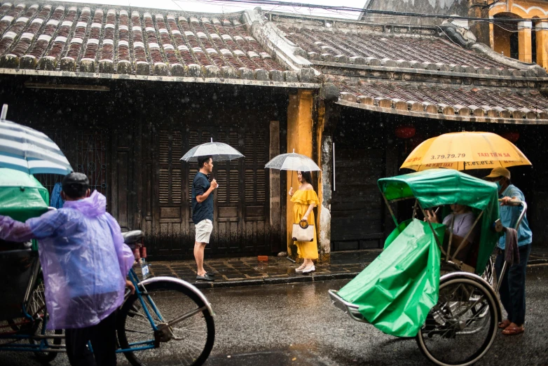 people are waiting to enter the building while holding umbrellas