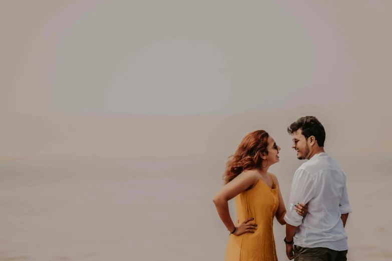 a couple looking into each others eyes standing near water