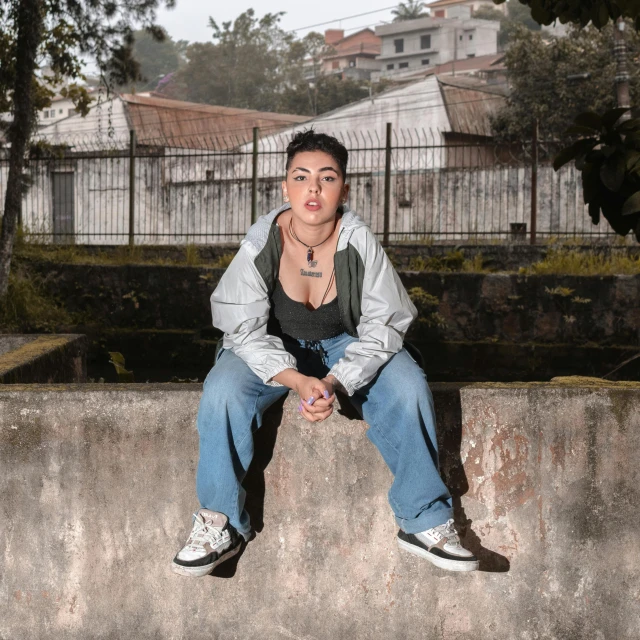 a young woman sitting on top of a cement bench