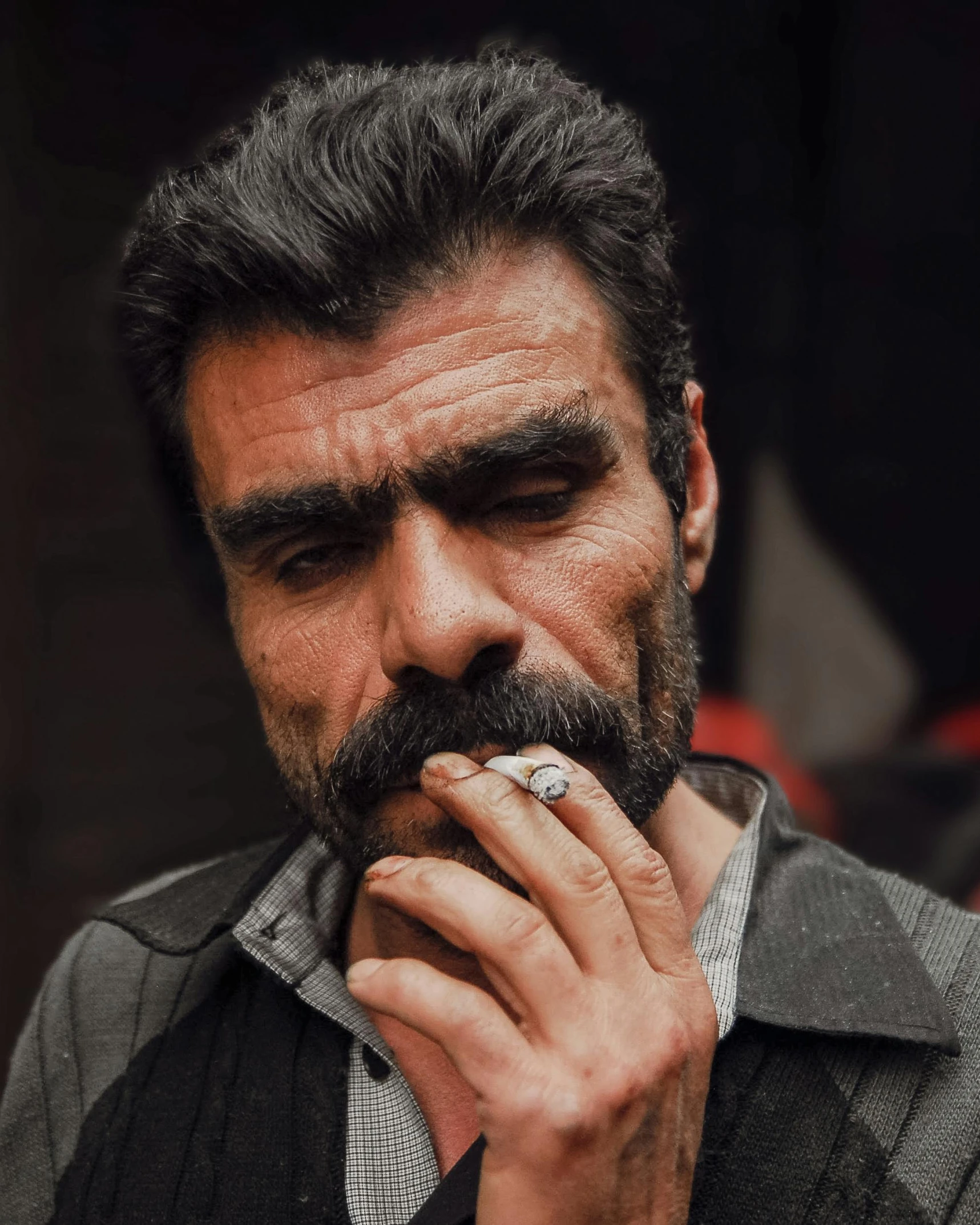 a bearded man smoking a cigarette in an outdoor environment