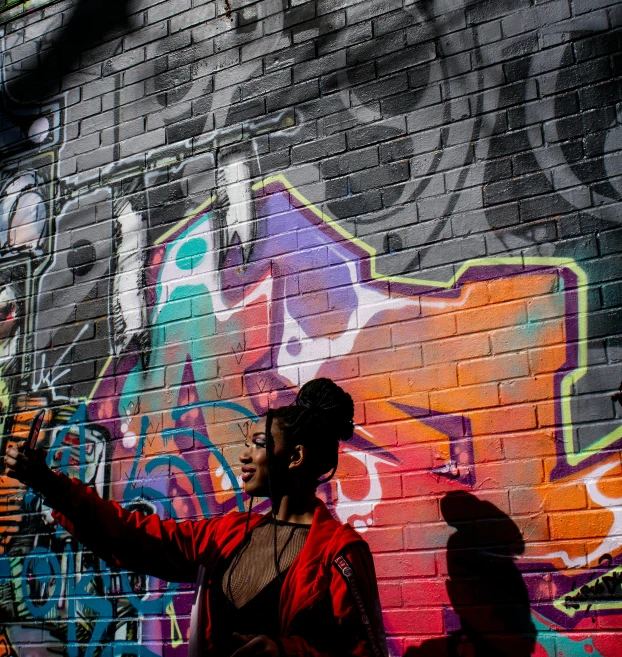 man standing in front of wall with graffiti on it