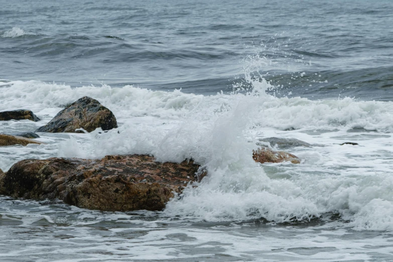 rough waves crash against the rocks on the beach