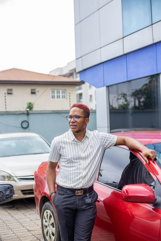 a man leaning against a red car