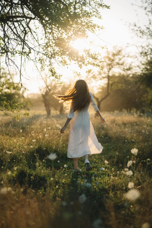 a girl wearing white is running in the sun