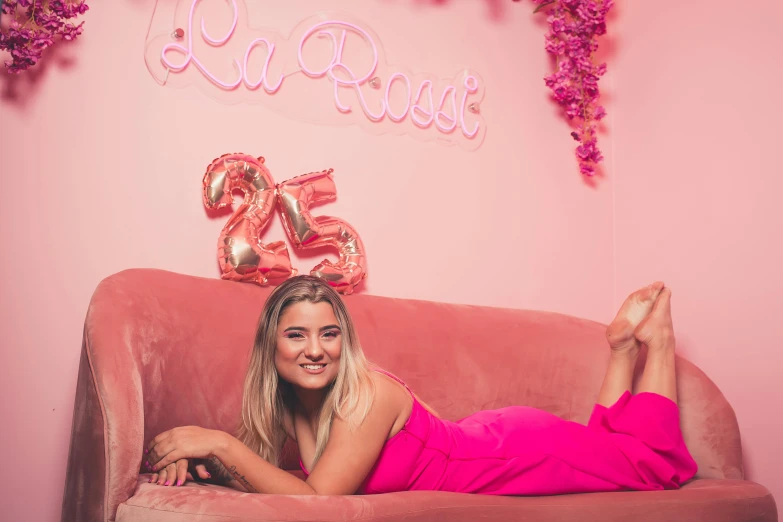 a woman laying on top of a pink couch