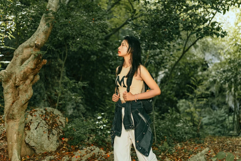 a man with dreadlocks standing by some trees