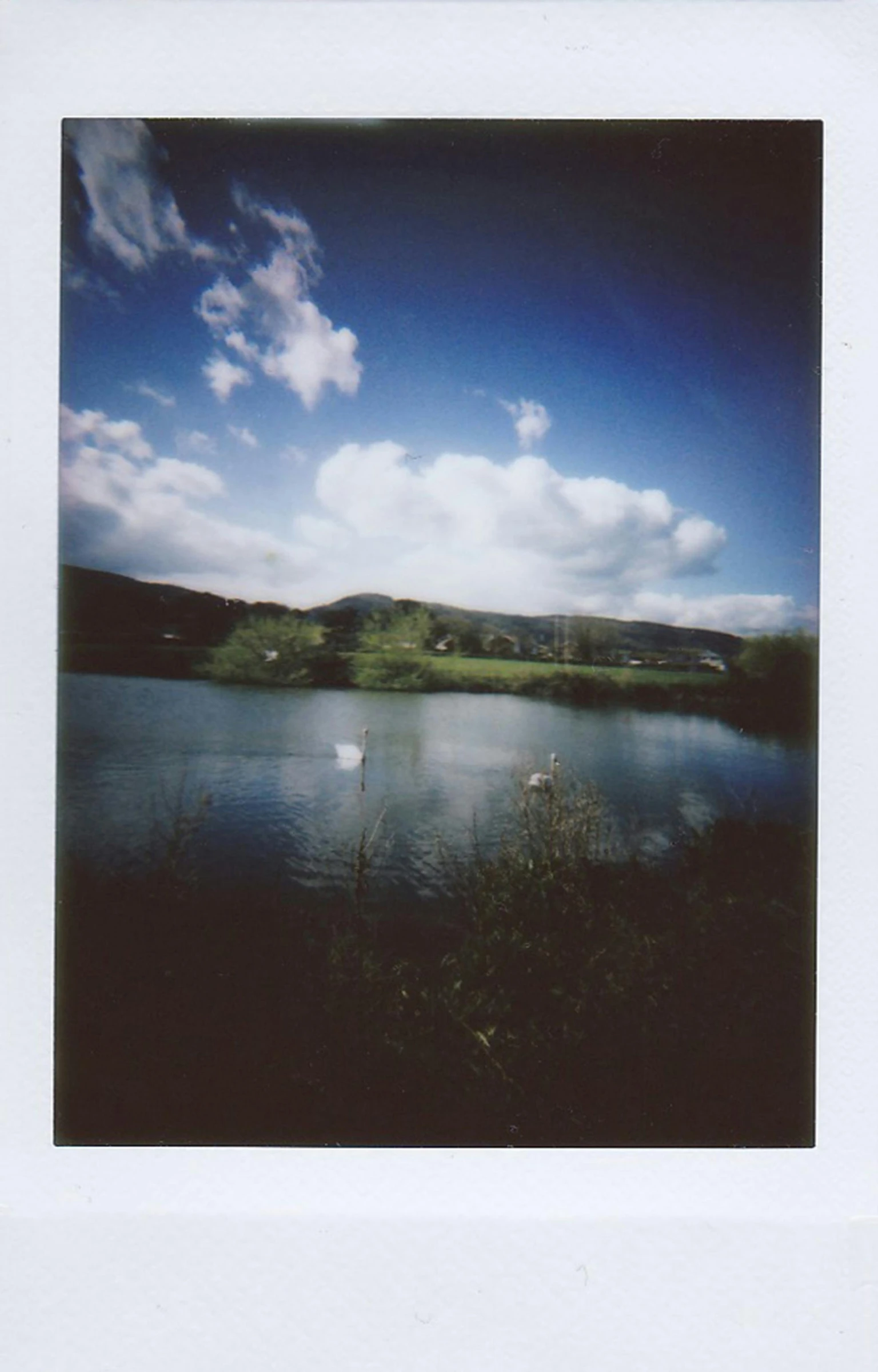 a lake with small boat in it in the middle of a countryside