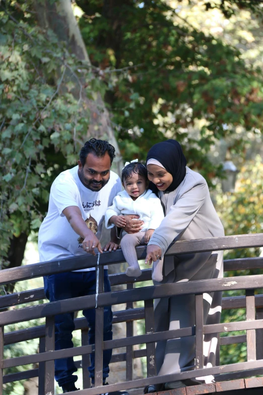 a family holding on to a wooden bridge