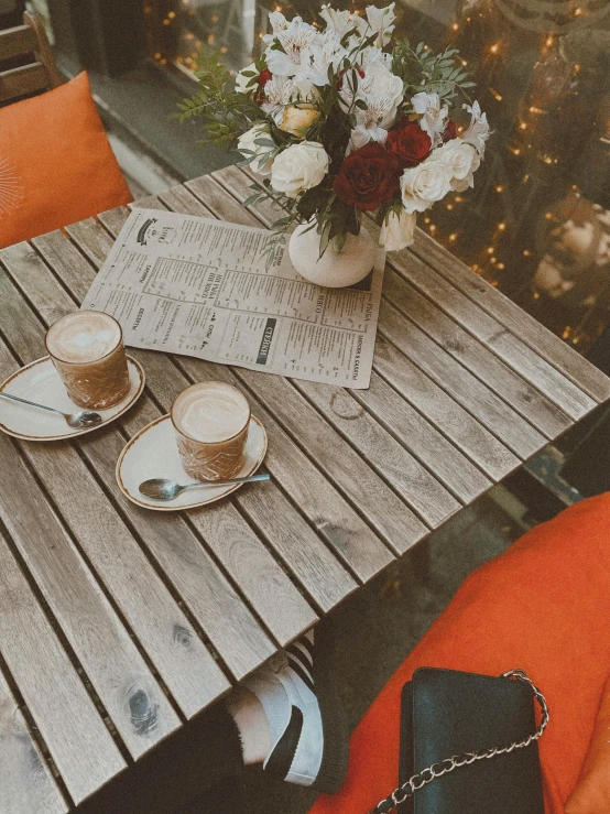 coffee cups on a table with newspapers in front of them