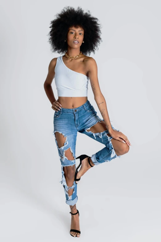 a young woman posing for a camera wearing ripped jeans