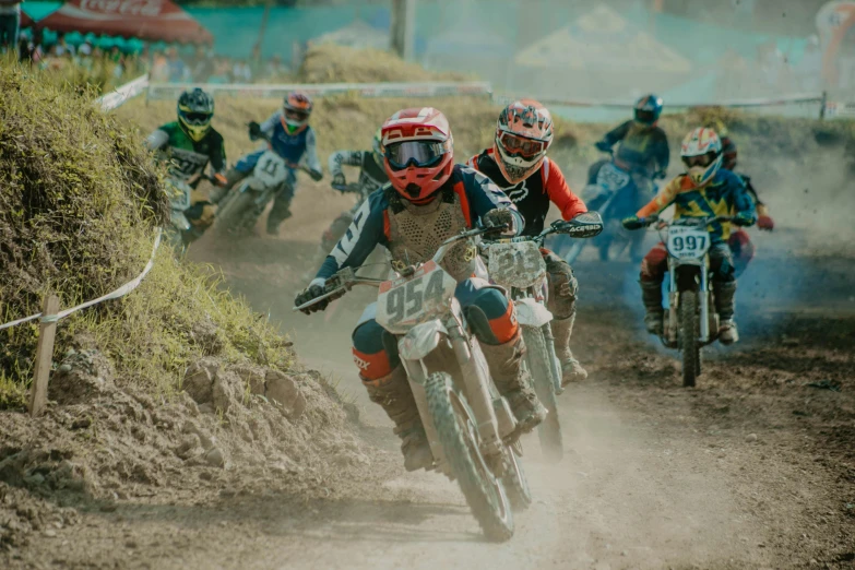 three dirt bikes riders on a dusty path