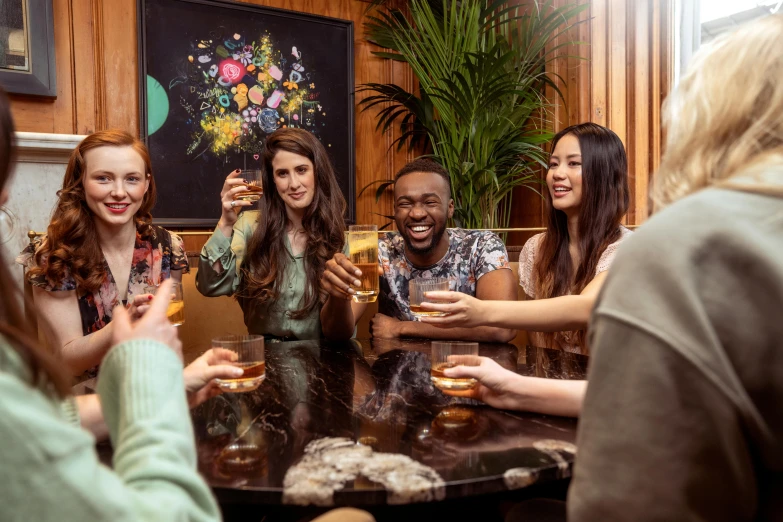 a group of women sitting at a table enjoying a beverage together