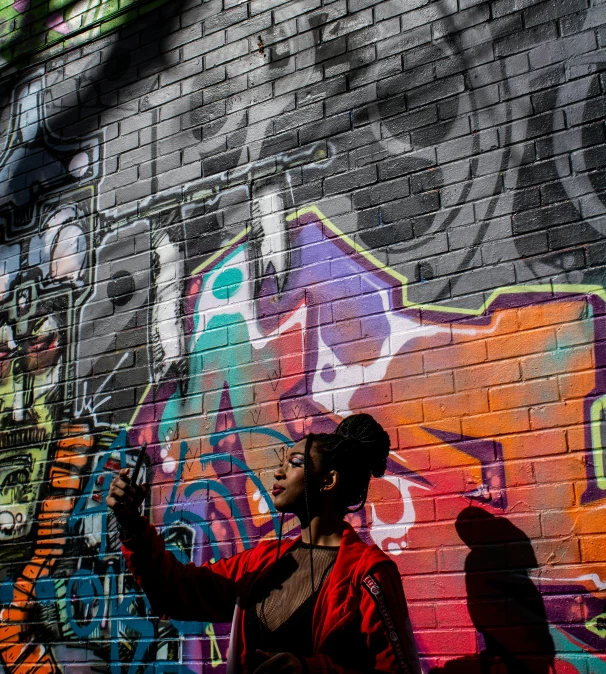 a person standing in front of a wall with graffiti