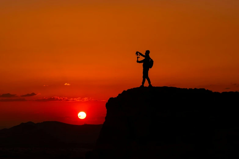 a person on top of a mountain holding a skateboard