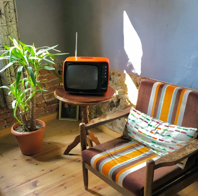 a television sitting on a table next to a chair