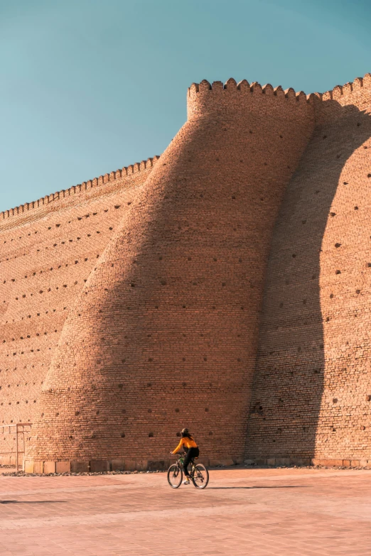 the person is riding their bike in front of the wall