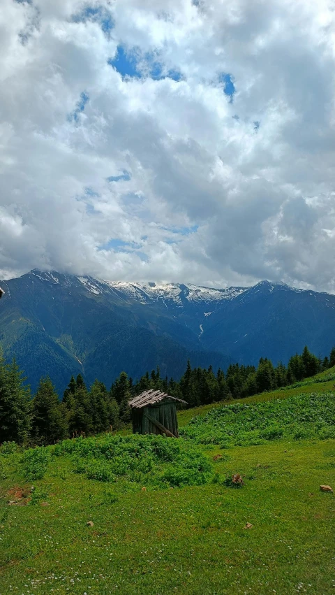 a small hut is sitting on top of the grassy hill