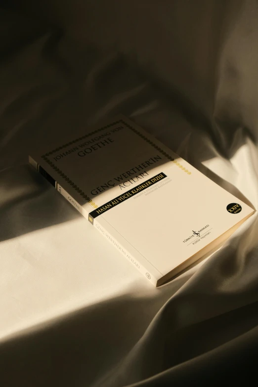 a book with a white cover laying on top of a bed