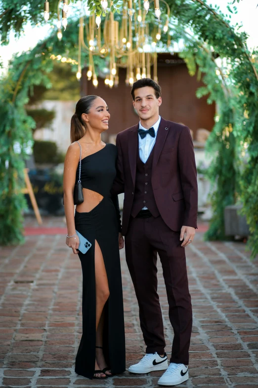a man and woman wearing prom wear posing together
