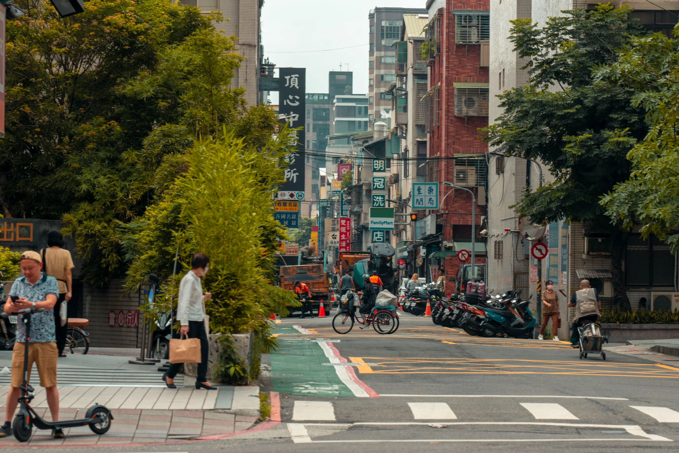 there are people walking and riding scooters on the street