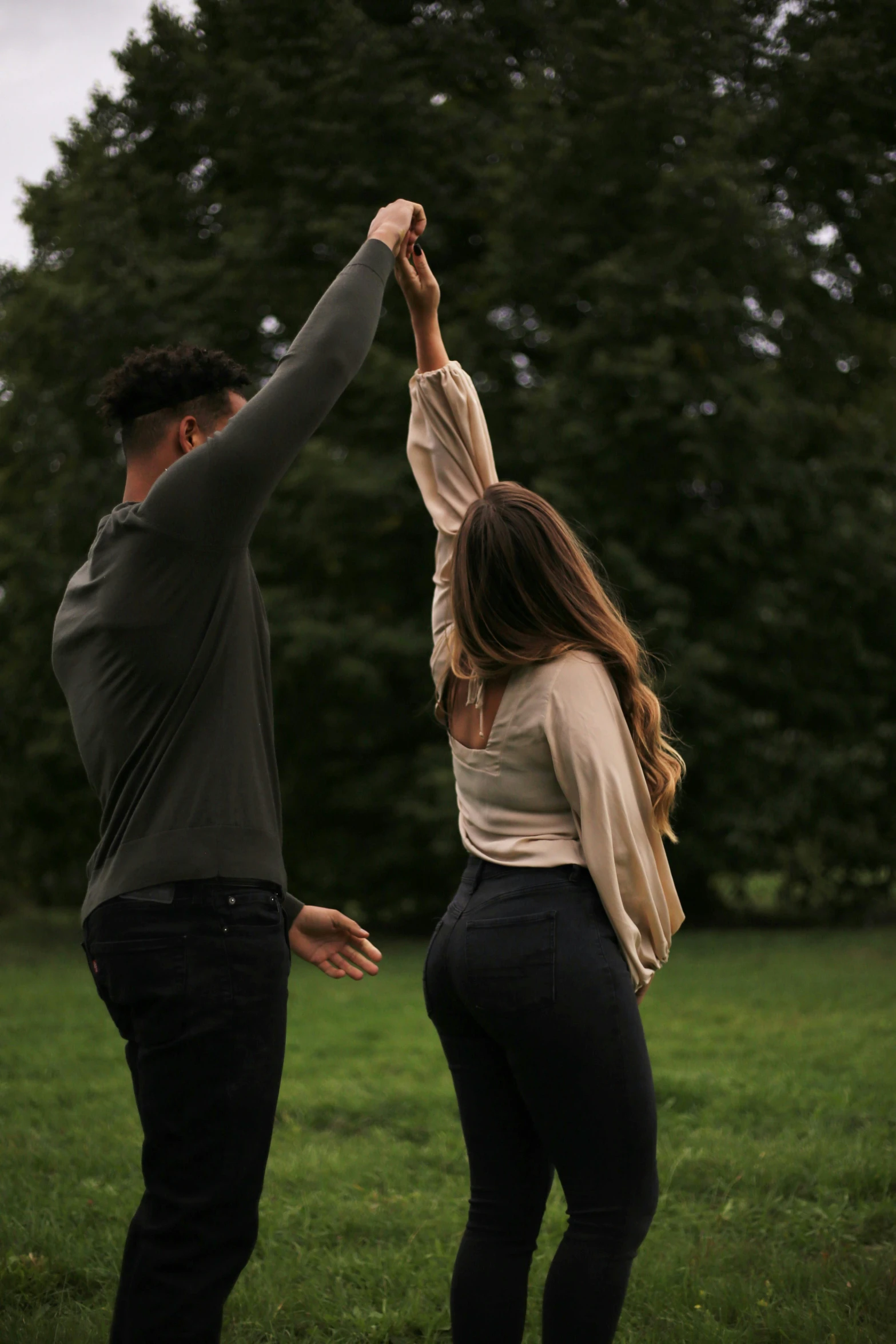 a young man and a young woman standing in a field