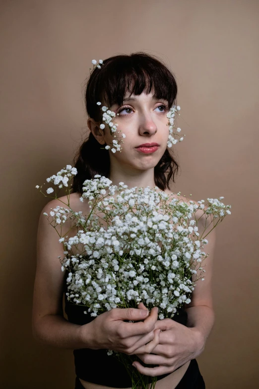 the young woman is holding some baby's breath flowers