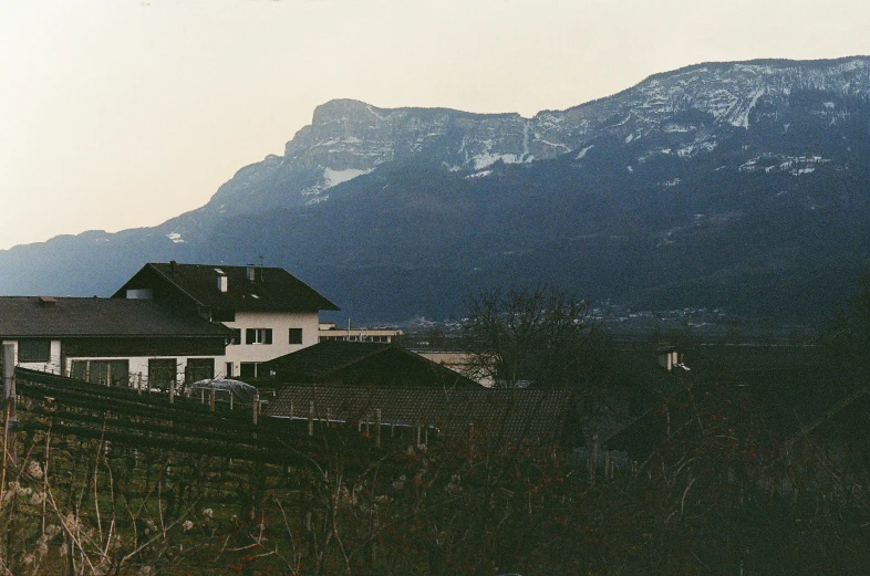 two houses in front of mountains with clouds