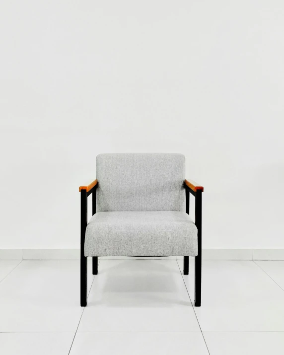 a grey chair sitting in an empty room