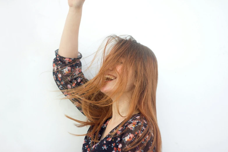 a girl with red hair has her head blowing in the wind