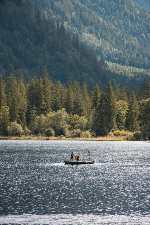 two people in a boat on a lake with trees