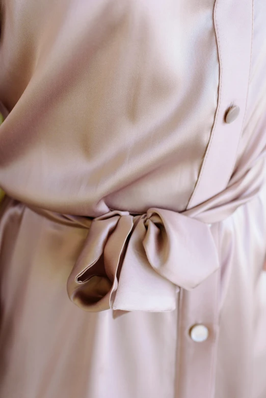 a woman wears a on - up shirt dress while holding a small flower