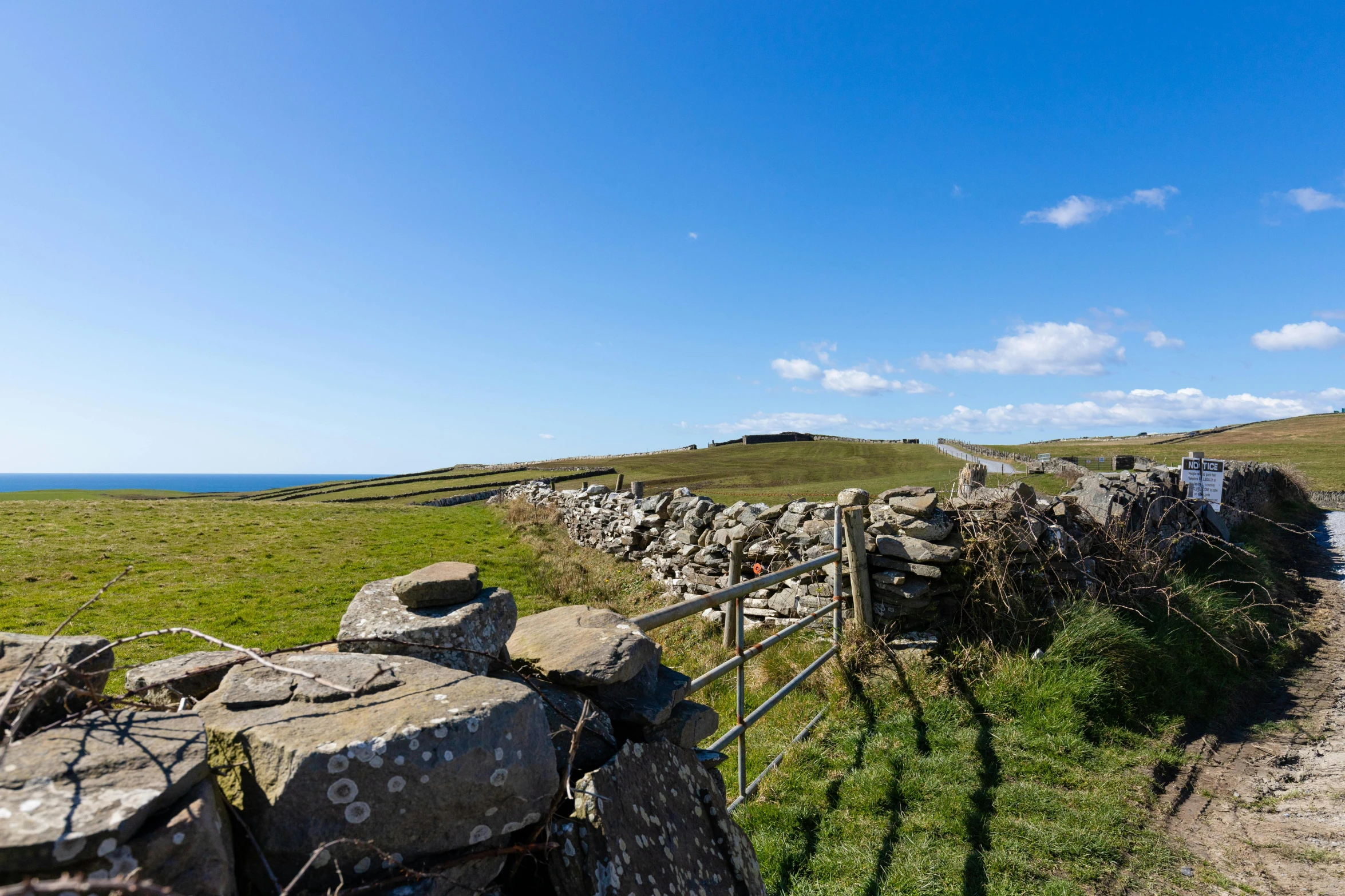 an old stone fence next to the ocean