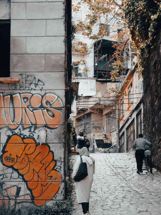 two people holding umbrellas walking down the street